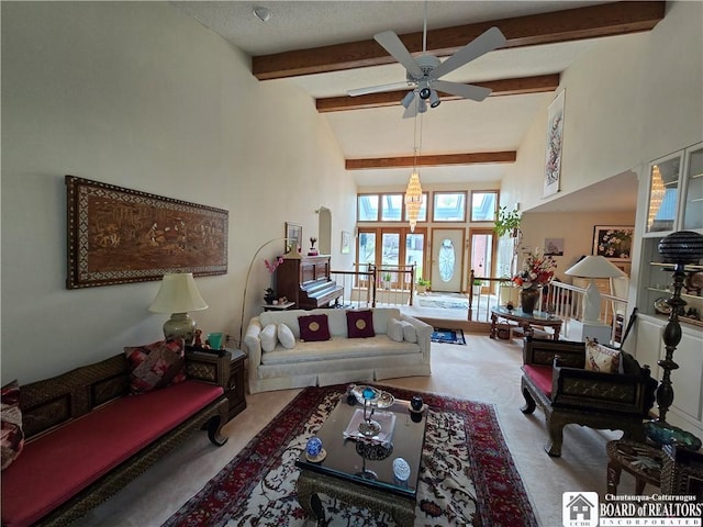 carpeted living room featuring beamed ceiling, ceiling fan, and high vaulted ceiling