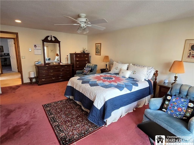 carpeted bedroom featuring a textured ceiling and a ceiling fan