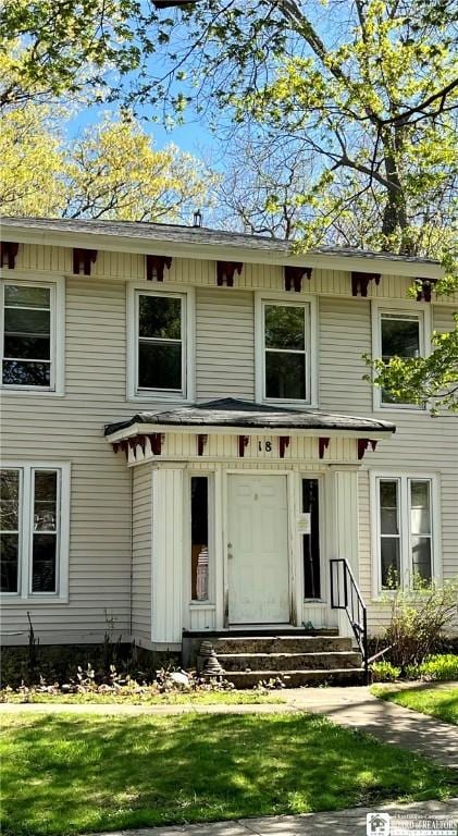 italianate-style house featuring a front lawn