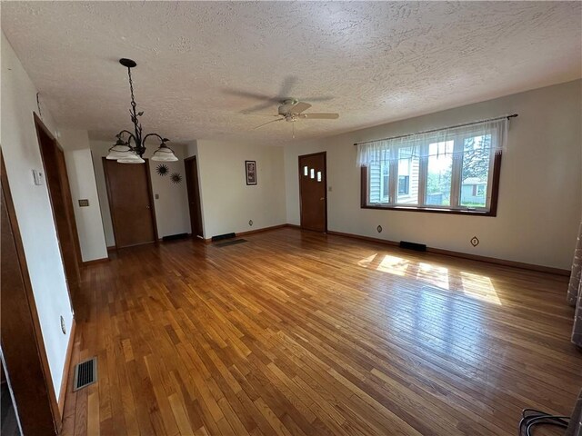48 King St, Mentz, NY 13140 - unfurnished living room featuring hardwood / wood-style flooring, a textured ceiling, ceiling fan, baseboards, and a chandelier