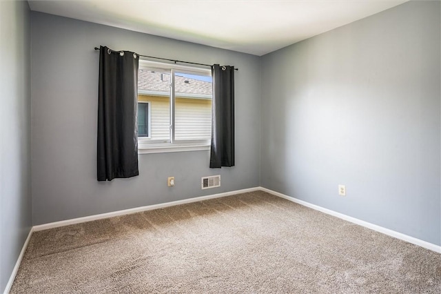 carpeted spare room with visible vents and baseboards