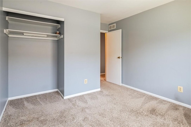 unfurnished bedroom featuring visible vents, a closet, carpet flooring, and baseboards