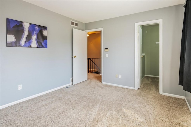unfurnished bedroom featuring visible vents, carpet floors, and baseboards