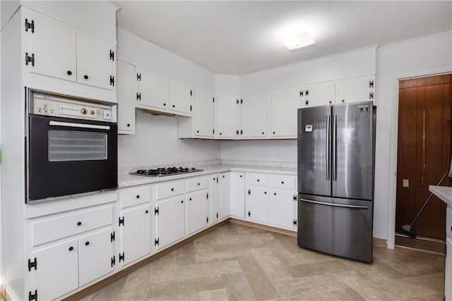 kitchen with white cabinets, stainless steel appliances, ornamental molding, and light countertops