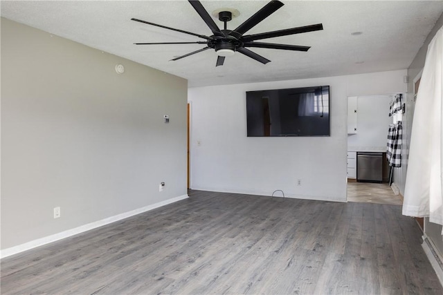 unfurnished living room with wood finished floors, a ceiling fan, and baseboards