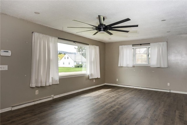 spare room featuring wood finished floors, ceiling fan, and baseboard heating