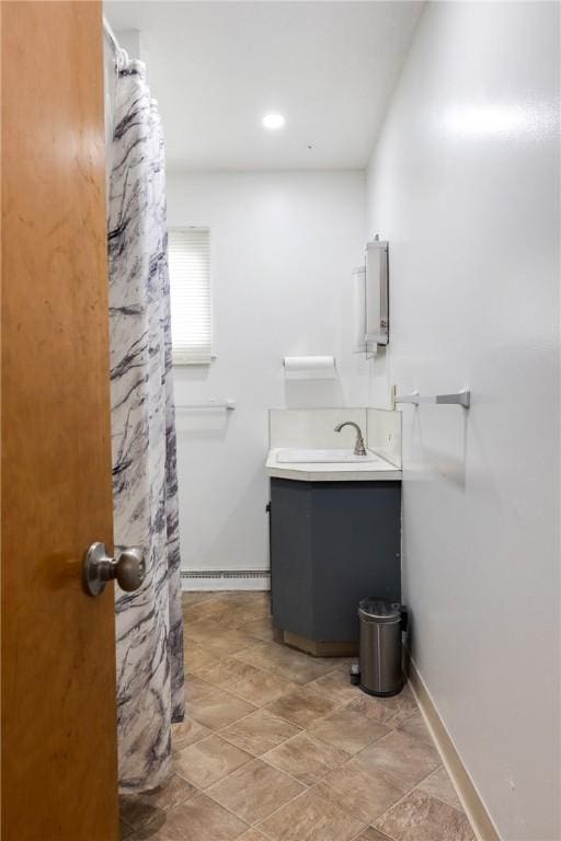 bathroom featuring baseboards, a shower with curtain, and vanity