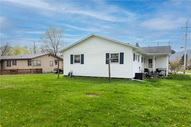 back of house featuring central AC and a lawn