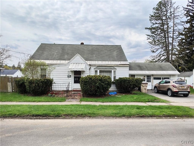 cape cod home with fence, concrete driveway, and roof with shingles