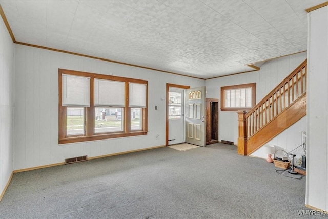entryway featuring stairway, visible vents, crown molding, and carpet flooring