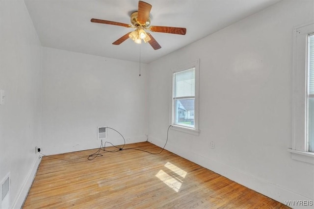 unfurnished room featuring baseboards, visible vents, a ceiling fan, and light wood-style flooring