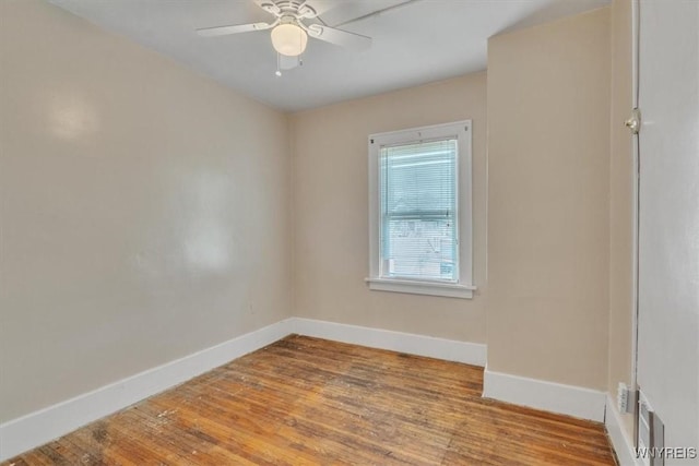 empty room with baseboards, wood finished floors, and ceiling fan