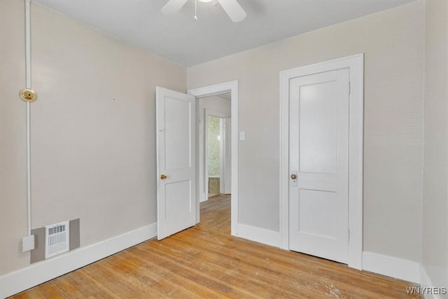 unfurnished bedroom featuring baseboards, visible vents, ceiling fan, and light wood-style flooring