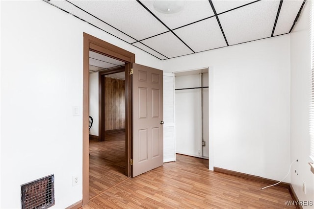 unfurnished bedroom featuring baseboards, light wood-type flooring, and visible vents