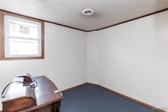 unfurnished office featuring crown molding, carpet floors, baseboards, and visible vents