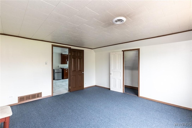 carpeted empty room with visible vents and baseboards