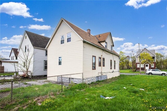 view of home's exterior featuring fence and roof with shingles