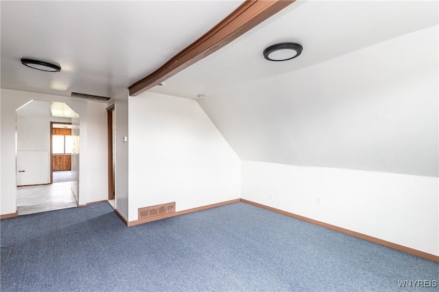 additional living space with carpet floors, baseboards, visible vents, and vaulted ceiling