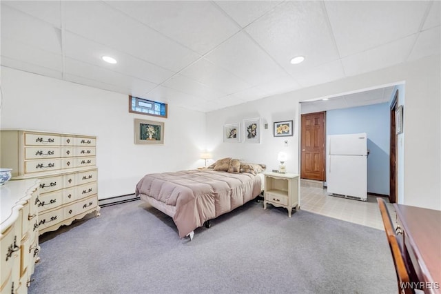 bedroom with recessed lighting, light colored carpet, a baseboard radiator, freestanding refrigerator, and a paneled ceiling