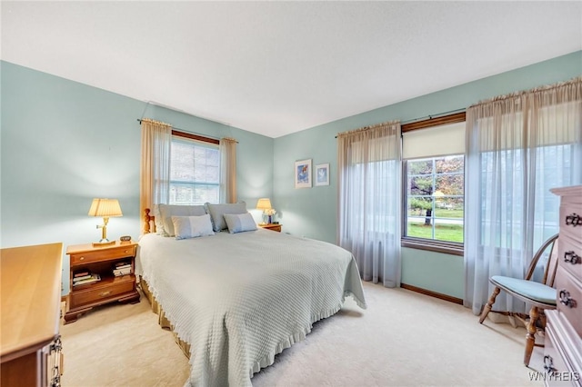 bedroom featuring light colored carpet and baseboards