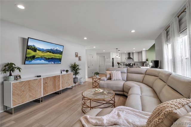 living room featuring baseboards, recessed lighting, and light wood finished floors
