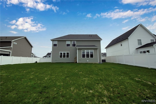back of house featuring a fenced backyard and a yard