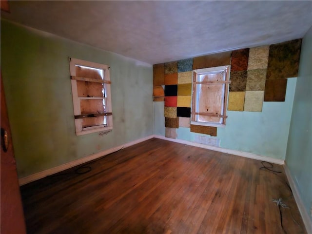 spare room featuring hardwood / wood-style floors and baseboards