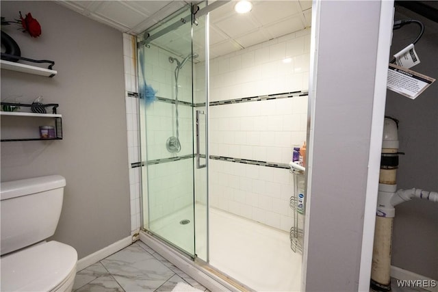 bathroom with baseboards, a stall shower, toilet, and marble finish floor