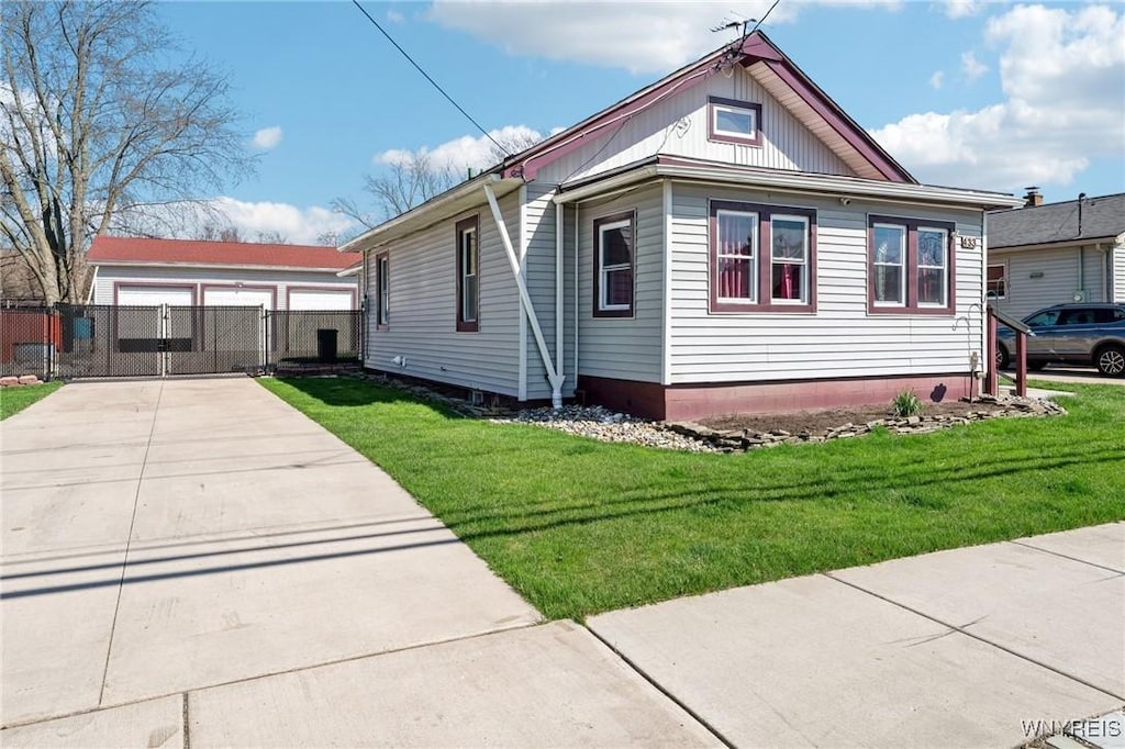 view of front of house with a front lawn, fence, driveway, and a gate