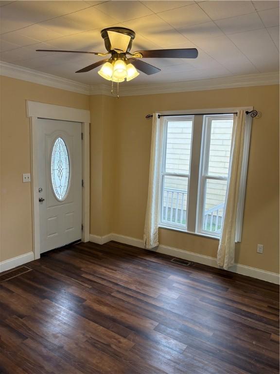 entrance foyer with crown molding, visible vents, baseboards, dark wood-style flooring, and a ceiling fan