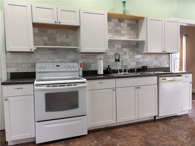 kitchen featuring tasteful backsplash, white appliances, dark countertops, a sink, and white cabinetry
