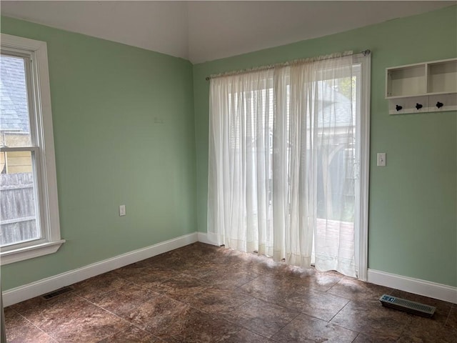 unfurnished room featuring plenty of natural light and baseboards