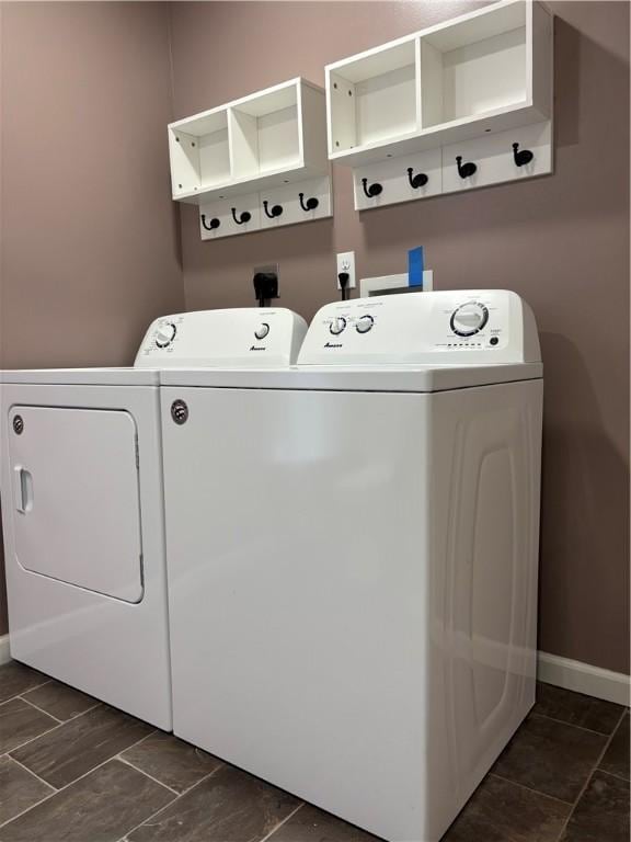 laundry room featuring washing machine and clothes dryer, laundry area, and baseboards