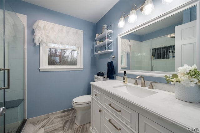 full bathroom with toilet, vanity, a shower stall, and baseboards