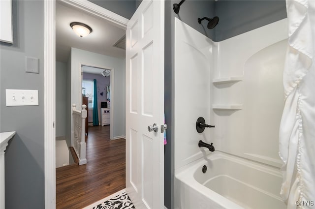 full bath featuring shower / tub combo and wood finished floors