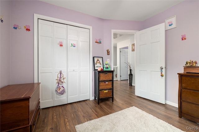 bedroom with a closet, baseboards, and dark wood-type flooring