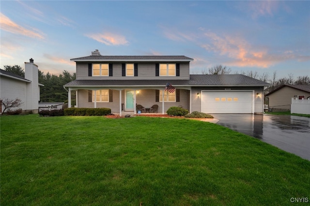 traditional home featuring concrete driveway, a chimney, a porch, a front lawn, and a garage