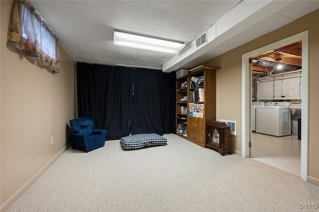 interior space with carpet floors, washing machine and clothes dryer, baseboards, visible vents, and a textured ceiling