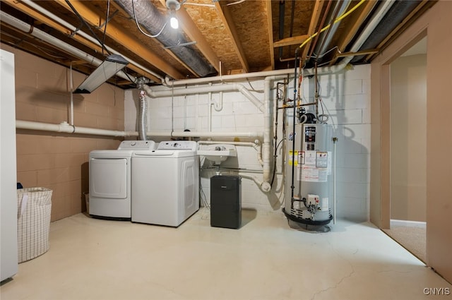 clothes washing area featuring a sink, water heater, laundry area, and washing machine and dryer
