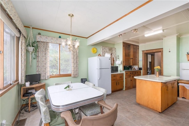 dining space featuring ornamental molding, light tile patterned flooring, and an inviting chandelier
