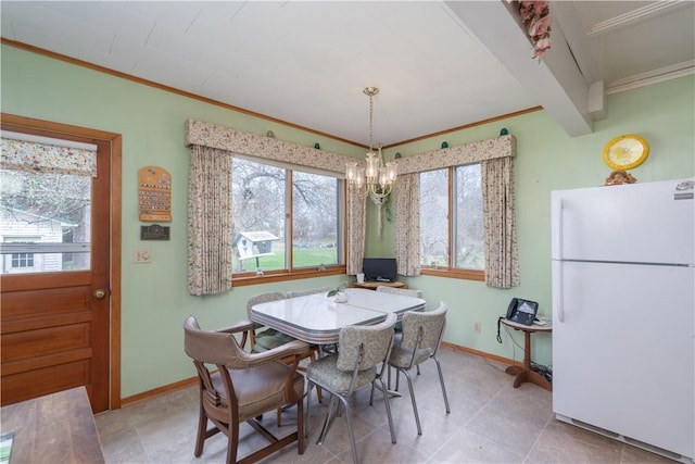 dining area featuring an inviting chandelier, ornamental molding, and baseboards