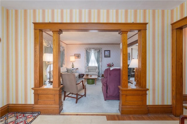 interior space with crown molding and decorative columns