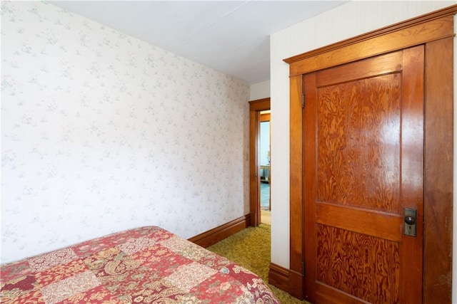 bedroom featuring a closet, carpet flooring, and wallpapered walls