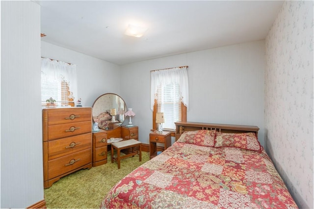 bedroom featuring wallpapered walls, light carpet, and multiple windows