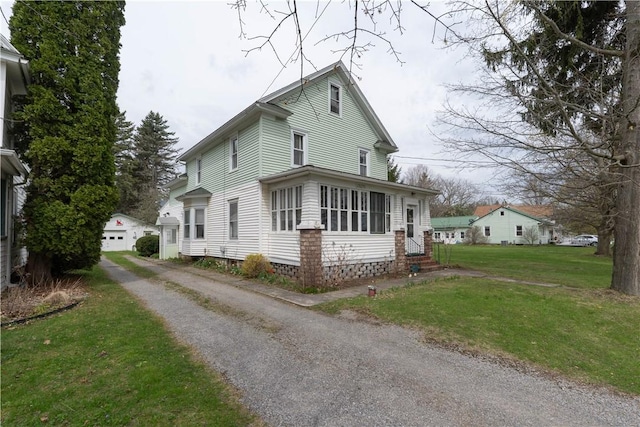 view of front of home featuring a detached garage, a front lawn, driveway, and entry steps