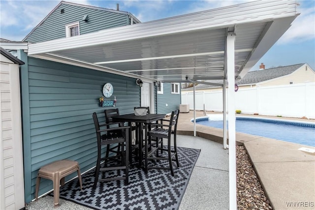 view of patio / terrace featuring outdoor dining area, a fenced in pool, and fence