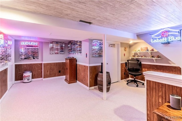 carpeted office with a wainscoted wall, a dry bar, wooden ceiling, and wood walls