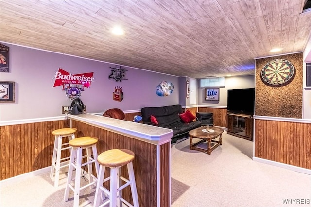 carpeted living room featuring wooden walls, a wainscoted wall, and wooden ceiling