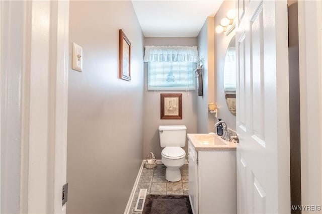 bathroom with visible vents, baseboards, toilet, vanity, and tile patterned flooring