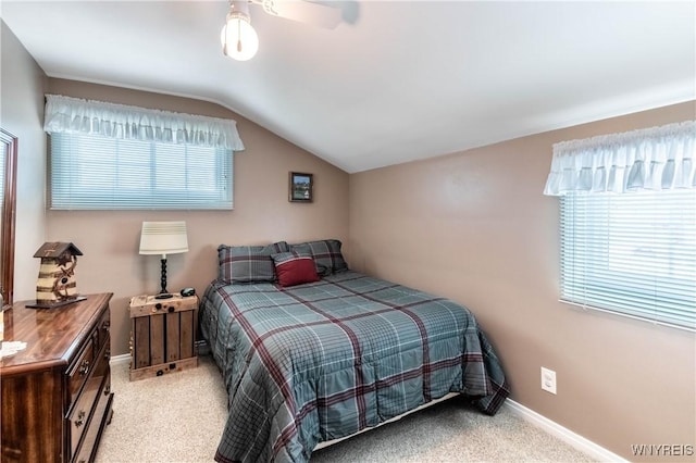 bedroom with multiple windows, vaulted ceiling, and light carpet
